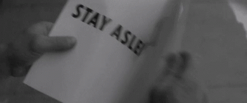 Hand holding a piece of paper with the text "STAY ASLEEP" in a black and white image.