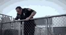 Struggling GIF - Kevin Can Wait Police Fence Hopping GIFs