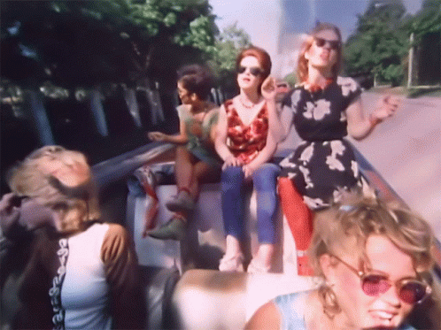 The Gogos, being driven in a convertible on a sunny day, jamming to the tunes